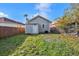 Small, grassy backyard with a wood fence and a detached structure; a cozy outdoor space for relaxation at 2317 W Chestnut St, Tampa, FL 33607