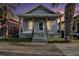 Evening view of a charming single-story home with a quaint front porch and well-maintained landscape at 2317 W Chestnut St, Tampa, FL 33607