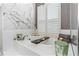 Bathroom features a soaking tub with marble accent wall, shutters and a modern chandelier, creating a relaxing spa-like feel at 2332 Dekan Ln, Land O Lakes, FL 34639