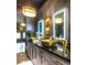Bathroom with dual gold vessel sinks, modern lighting, and gray cabinets create an elegant and luxurious space at 2332 Dekan Ln, Land O Lakes, FL 34639