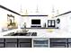 Bright, open kitchen with a marble island, black cabinets, and stainless steel appliances at 2332 Dekan Ln, Land O Lakes, FL 34639