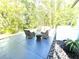 Outdoor patio with wicker furniture, a small table, and lush landscaping offering a peaceful retreat at 2332 Dekan Ln, Land O Lakes, FL 34639