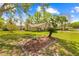 Charming home featuring a well-manicured lawn, mature trees, and a cozy screened-in porch at 24076 Ragan Dr, Brooksville, FL 34601