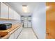 Spacious laundry room offers ample storage with white cabinets, a utility sink, and modern appliances at 24076 Ragan Dr, Brooksville, FL 34601