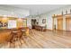 Open living area with wood-look floors, a breakfast bar, dining table, and an abundance of natural light at 24076 Ragan Dr, Brooksville, FL 34601