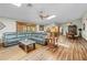 Open-concept living area boasts wood-look floors, a ceiling fan, and access to the kitchen and dining room at 24076 Ragan Dr, Brooksville, FL 34601