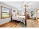 Main bedroom featuring a canopy bed, hardwood floors, and two windows at 24076 Ragan Dr, Brooksville, FL 34601