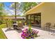 Spacious patio featuring an outdoor seating area surrounded by lush landscaping and vibrant flower pots at 24076 Ragan Dr, Brooksville, FL 34601