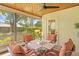 Relaxing screened-in porch with a ceiling fan and wicker furniture to relax and enjoy the outdoors at 24076 Ragan Dr, Brooksville, FL 34601