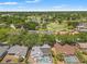 An aerial view of a home with a screened-in pool overlooking a nearby golf course and lush greenery at 2554 Brimhollow Dr, Valrico, FL 33596