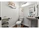 Stylish half-bathroom featuring a pedestal sink, elegant fixtures, and modern wood-look floors at 2554 Brimhollow Dr, Valrico, FL 33596