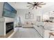 Open-concept living room with a fireplace, TV, and comfortable white seating next to an adjacent kitchen at 2554 Brimhollow Dr, Valrico, FL 33596