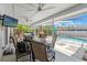 Screened-in pool with an outdoor TV, chairs, and a table under a covered patio at 2554 Brimhollow Dr, Valrico, FL 33596