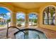 Inviting hot tub area with arched openings overlooking the pool and palm trees at 2773 Via Cipriani # 1322A, Clearwater, FL 33764