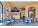 Outdoor kitchen and covered seating area with tables, chairs, and a mounted television at 2773 Via Cipriani # 1322A, Clearwater, FL 33764