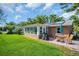 Manicured backyard features a grill, solar panels, lanai and luscious green lawn at 2814 Lomond Dr, Palm Harbor, FL 34684