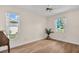 Bright bedroom with wood-look flooring has two windows allowing plenty of natural light at 2814 Lomond Dr, Palm Harbor, FL 34684