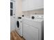 Bright laundry room features a washer and dryer with cabinets for storage and wood-look flooring at 2814 Lomond Dr, Palm Harbor, FL 34684