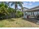 Landscaped backyard with a covered patio featuring brick outdoor fireplace, table and chairs, perfect for outdoor entertaining at 2815 W Estrella St, Tampa, FL 33629