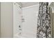 White tiled bathtub with a shower and patterned shower curtain at 2815 W Estrella St, Tampa, FL 33629