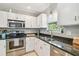 Bright kitchen featuring stainless steel appliances, granite counters, and white cabinets at 2815 W Estrella St, Tampa, FL 33629