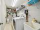 Well-organized laundry room with washer, dryer, sink, and ample shelving for storage at 2815 W Estrella St, Tampa, FL 33629