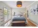 Bright bedroom with white furniture, shuttered door, and wooden floors and a blue and copper colored lighting fixture at 2815 W Estrella St, Tampa, FL 33629
