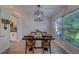 Bright dining room with wood floors, rustic chairs, and large window offering outdoor view at 28834 Stormcloud Pass, Wesley Chapel, FL 33543