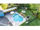 Aerial view of the pool area, with a covered lounge, backyard, and lawn at 30647 Walker Cup Pl, Wesley Chapel, FL 33543