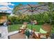 Backyard lawn with rocking chair seating area, playground, and view of the pool at 30647 Walker Cup Pl, Wesley Chapel, FL 33543