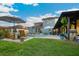 Backyard lawn with a view of the pool, covered lounge, outdoor grill, and patio seating at 30647 Walker Cup Pl, Wesley Chapel, FL 33543