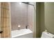 Bathroom with shower featuring light gray tile and a bathtub at 30647 Walker Cup Pl, Wesley Chapel, FL 33543