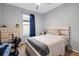 Cozy bedroom with neutral walls, a large window, and furnished with a wooden bed frame and desk at 30647 Walker Cup Pl, Wesley Chapel, FL 33543