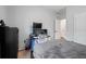 Bedroom with a gray bed cover, neutral walls and a desk setup near the window at 30647 Walker Cup Pl, Wesley Chapel, FL 33543