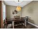 Inviting dining room with a wooden table, seating for six, and a unique pendant light fixture at 30647 Walker Cup Pl, Wesley Chapel, FL 33543