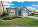 Well-maintained blue house with a lush green lawn and a convenient two-car garage at 30647 Walker Cup Pl, Wesley Chapel, FL 33543