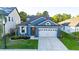 Beautiful blue home with a well-maintained lawn, landscaping, and a spacious two-car garage at 30647 Walker Cup Pl, Wesley Chapel, FL 33543