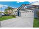 Charming blue home featuring a well-manicured lawn and a convenient two-car garage at 30647 Walker Cup Pl, Wesley Chapel, FL 33543
