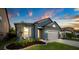 Lovely blue home highlighting manicured landscaping, a spacious driveway, and warm exterior lighting at 30647 Walker Cup Pl, Wesley Chapel, FL 33543