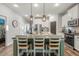 Bright kitchen featuring an island with barstool seating, modern fixtures, and stainless steel appliances at 30647 Walker Cup Pl, Wesley Chapel, FL 33543