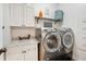 Well-organized laundry room with modern washer, dryer, and ample storage cabinets, creating a functional space at 30647 Walker Cup Pl, Wesley Chapel, FL 33543