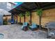 Outdoor patio features blue patio chairs, outdoor kitchen and hanging ferns at 30647 Walker Cup Pl, Wesley Chapel, FL 33543