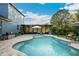 Inviting backyard pool with brick pavers, a seating area, barbecue grill, and lush landscaping at 30647 Walker Cup Pl, Wesley Chapel, FL 33543