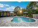 Beautiful backyard pool with brick pavers, sun umbrellas, lounge seating, and lush landscaping at 30647 Walker Cup Pl, Wesley Chapel, FL 33543