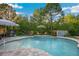 Backyard pool with a seating area, play set, beautiful stone work, and landscaping at 30647 Walker Cup Pl, Wesley Chapel, FL 33543