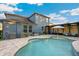 Backyard pool with brick pavers, AC, sun umbrella, and the home's exterior at 30647 Walker Cup Pl, Wesley Chapel, FL 33543
