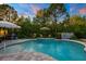 Beautiful backyard pool with a tranquil water feature, lush greenery, and outdoor seating at 30647 Walker Cup Pl, Wesley Chapel, FL 33543