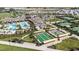 Aerial view showcases a community pool, bocce ball, tennis courts, and lush landscaping, offering a resort-style living at 31764 Griffin Sands Ln, San Antonio, FL 33576