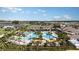 Aerial view of resort-style pool with palm trees, lounge chairs, and community amenities at 31764 Griffin Sands Ln, San Antonio, FL 33576