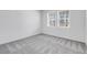 A bedroom is brightly lit by two windows and a neutral, soft carpet at 31764 Griffin Sands Ln, San Antonio, FL 33576